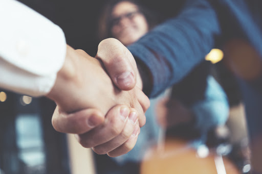 53a9973649bc46f8813980247c7e7e82 Business people shaking hands in the office after succesful meeting. Three persons
